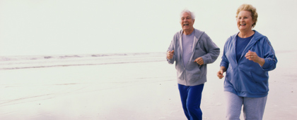 older couple jogging on the beach